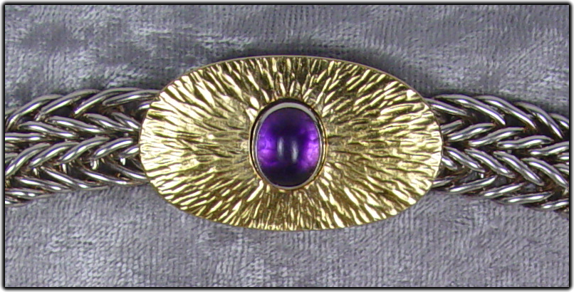 This clasp has an 8 x 10 mm amethyst cabochon pushbutton that releases its catch.