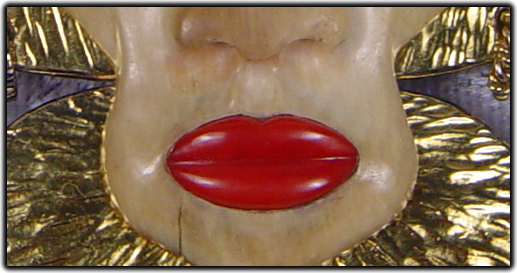 The face is carved from mastodon ivory and its lips are made of red coral